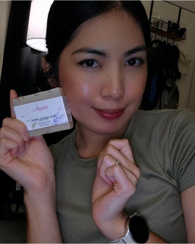 Woman holding a lavender soap bar with a neutral background