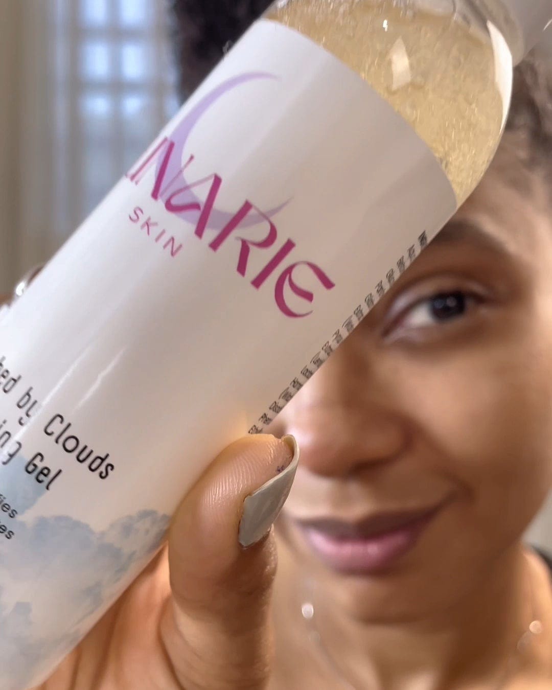 Person holding a bottle labeled 'NARIE' with a blurred background