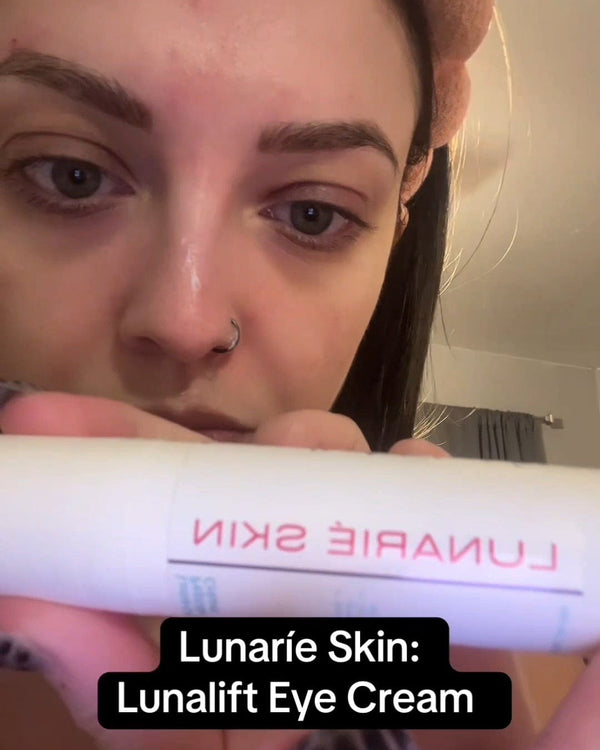Person holding a container of Lunarie Skin Lunalift Eye Cream with a blurred background.